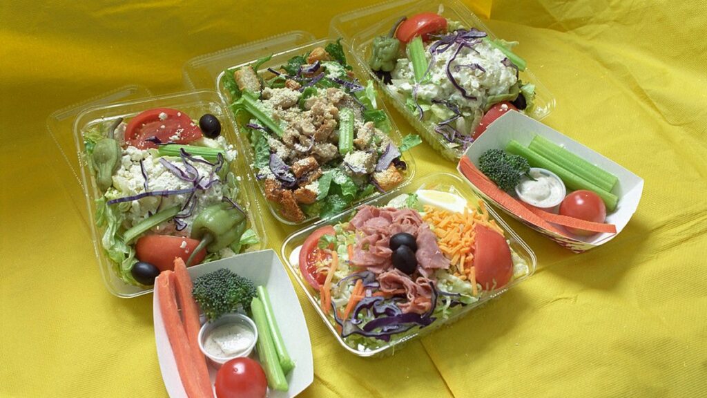 Meal prep containers filled with grains, vegetables and protein on a kitchen counter