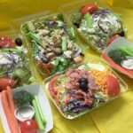 Meal prep containers filled with grains, vegetables and protein on a kitchen counter