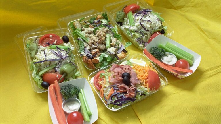 Meal prep containers filled with grains, vegetables and protein on a kitchen counter