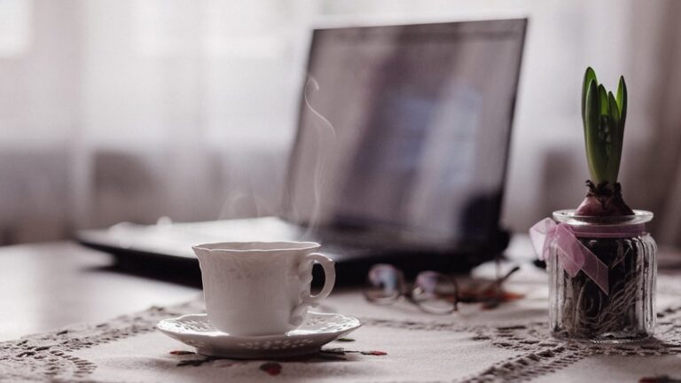 Morning sunlight on a kitchen table with a cup of coffee and an open notebook